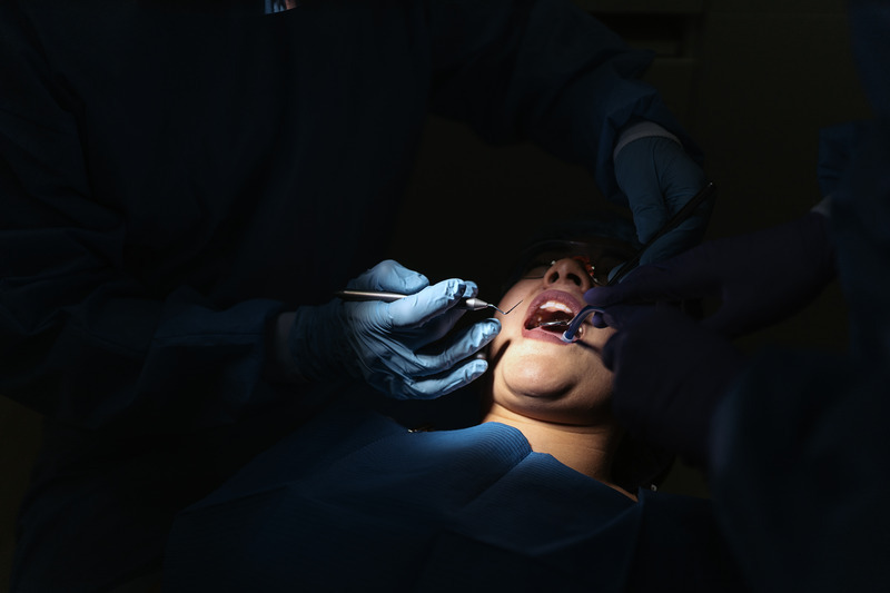 Dental procedure in a dimly lit clinic